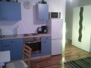 a kitchen with blue cabinets and a white refrigerator at Ferienwohnung Karla - nahe Chemnitz in Limbach-Oberfrohna