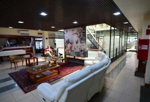 a living room with white couches and a fireplace at Tur Hotel Santiago in Santiago