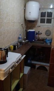 a small kitchen with a stove and a sink at El Fardous Flowerللرجال فقط in Alexandria