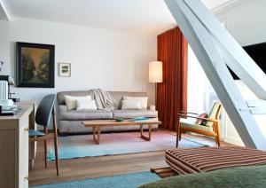 a living room with a couch and a table at Auberge Du Père Bise - Jean Sulpice in Talloires
