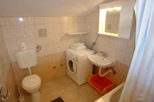 a small bathroom with a toilet and a sink at Apartments Tinka in Povljana +46 photos