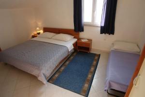 a small bedroom with a bed and a window at Apartments Tinka in Povljana