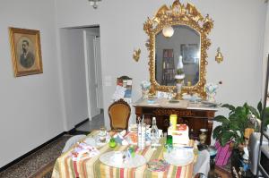 una sala da pranzo con tavolo e specchio di Il Ciottolo a Genova