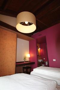 1 dormitorio con paredes de color púrpura, 1 cama y luz en Agriturismo Tetto Garrone, en Cuneo
