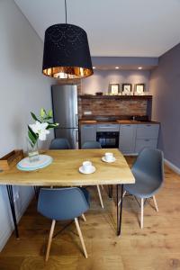 a kitchen and dining room with a wooden table and chairs at Jewish Quarter Comfort - In City Apartments in Krakow