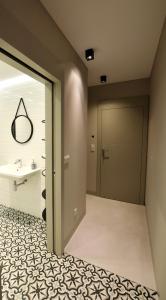 a bathroom with a door and a tile floor at Jewish Quarter Comfort - In City Apartments in Krakow