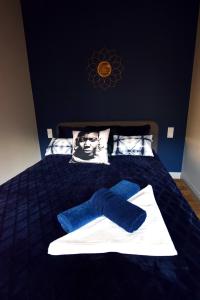 a bed with a blue blanket and a picture of a man at Jewish Quarter Comfort - In City Apartments in Krakow