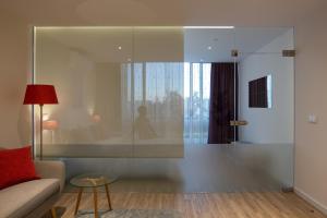 a living room with a glass shower with a woman sitting on the window at CASA JOY Vilamoura apartment in Vilamoura