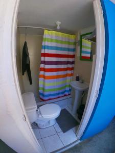 a bathroom with a toilet and a shower curtain at Urcia Surf House in Huanchaco