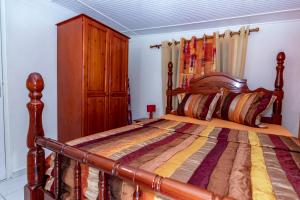 een slaapkamer met een bed met een houten hoofdeinde bij Gîte 2ch proche plages, Jardin privé, Port-Louis in Port-Louis