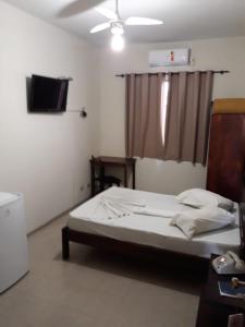 um quarto com uma cama e uma televisão em HOTEL LAREIRA em São José dos Campos