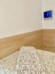 a bedroom with a bed and a tv on the wall at Апартаменти для пари в центральній частині Львова in Lviv