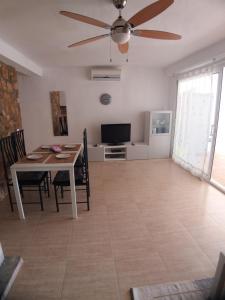 ein Wohnzimmer mit einem Tisch und einem Deckenventilator in der Unterkunft Fantástico Apartamento 1ª Línea de Playa in Cambrils