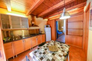 a kitchen with wooden cabinets and a table at Son de Mar 1 in Cefalù