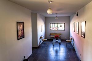 a hallway with chairs and a table and a window at Pousada Paraiso in Guanambi