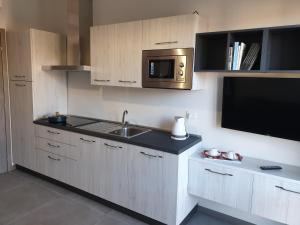 una cucina con lavandino e forno a microonde di Sun Lake Apartments a Desenzano del Garda