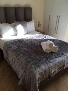 a bedroom with a large bed with two towels on it at Blue Sky Apartments@The Centrium, Woking in Woking