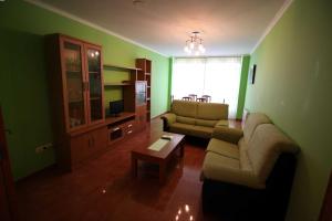 sala de estar con sofá y mesa en Pisos Buño, en Buño