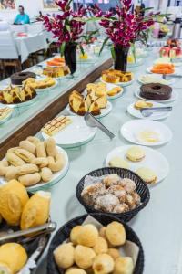 a long table with plates of food on it at Pousada Paraiso in Guanambi
