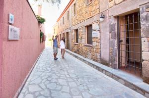 a man and a woman walking down a alley at The Varos Residences Hotel in Város