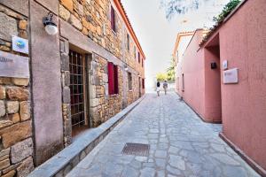 a stone alley with two people walking down the street at The Varos Residences Hotel in Város