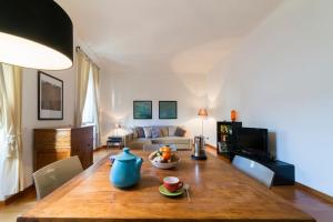 un soggiorno con tavolo e vaso blu di Borgo Pinti Frescos 6 sleeps a Firenze