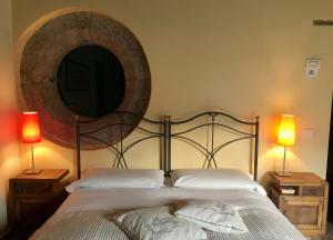 una camera da letto con un letto con uno specchio e due lampade di B&B Bellini a Napoli
