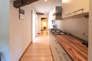 a kitchen with white cabinets and a wooden floor at Apartments Waldquell in Collalbo