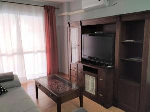 a living room with a tv and a coffee table at Natipao in Rota