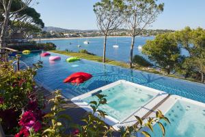 una gran piscina con vistas a un cuerpo de agua en Alàbriga Hotel & Home Suites GL, en S'Agaró