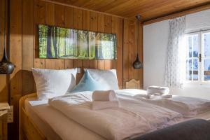 a bedroom with two beds with white sheets and a window at Berg'k'hof Kaisertal - Alpine Hideaway in Ebbs