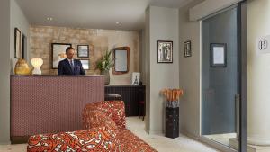 a man standing at a counter in a room at Hôtel Belloy Saint Germain in Paris