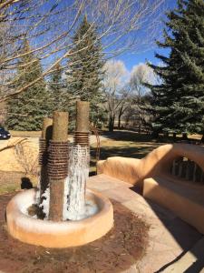 a fountain in a park with snow on it at Old Taos Guesthouse B&B in Taos