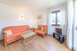 a living room with a bed and a couch and a tv at Apartment Nerea in L'Escala