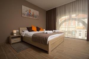 a bedroom with a large bed and a large window at Centar lux 2 in Zrenjanin