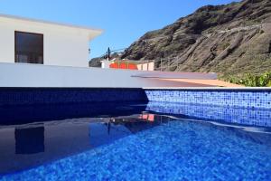 a pool of water next to a house with a mountain at Casa Vista Caldera in Tijarafe