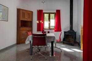 ein Esszimmer mit einem Tisch und roten Vorhängen in der Unterkunft Casa Vista Caldera in Tijarafe