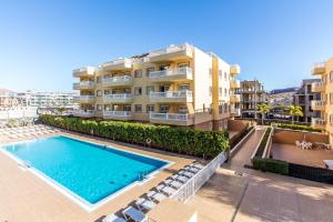 an apartment with a swimming pool in front of a building at Duplex Palm Mar C27 in Palm-Mar