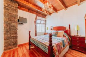 a bedroom with a bed and a stone wall at Villa Matta in Santana +34 photos