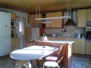 - une cuisine avec une table blanche et des chaises dans l'établissement Pyhtää Garden Villa, à Pyhtaa