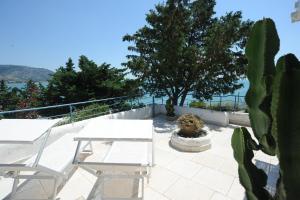 een patio met tafels en stoelen en een cactus bij case vacanza montesaraceno in Mattinata