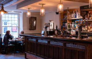 un bar in un pub con persone sedute ai tavoli di White Hart Inn a Wells
