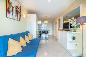 a living room with a blue couch and a kitchen at EL DORADO SEA VIEW 2A015 in Arona