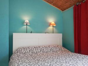 a bedroom with a bed and two lamps on the wall at Les Cigalous in Salavas