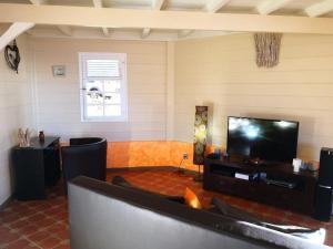 a living room with a flat screen tv at La Villa Kanel in Les Anses-dʼArlets