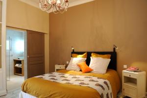 Schlafzimmer mit einem Bett mit orangefarbenen und weißen Kissen in der Unterkunft La Villa Sainte Catherine in Andernos-les-Bains