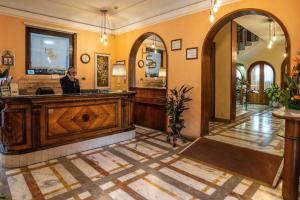 un hombre de pie en una peluquería en Hotel Santa Prisca en Roma