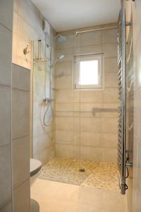 ein Bad mit einer Dusche und einer Glastür in der Unterkunft La Villa Sainte Catherine in Andernos-les-Bains