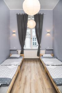 a room with two beds and a window at Hostel Krakowskie Klimaty in Krakow