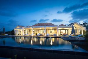 a large house with a swimming pool at night at Villa Dolphin Saint Martin in Orient Bay